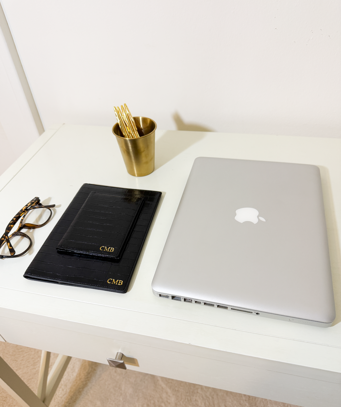 laptop with monogrammed croc passport case, notebook case, glasses, and pens