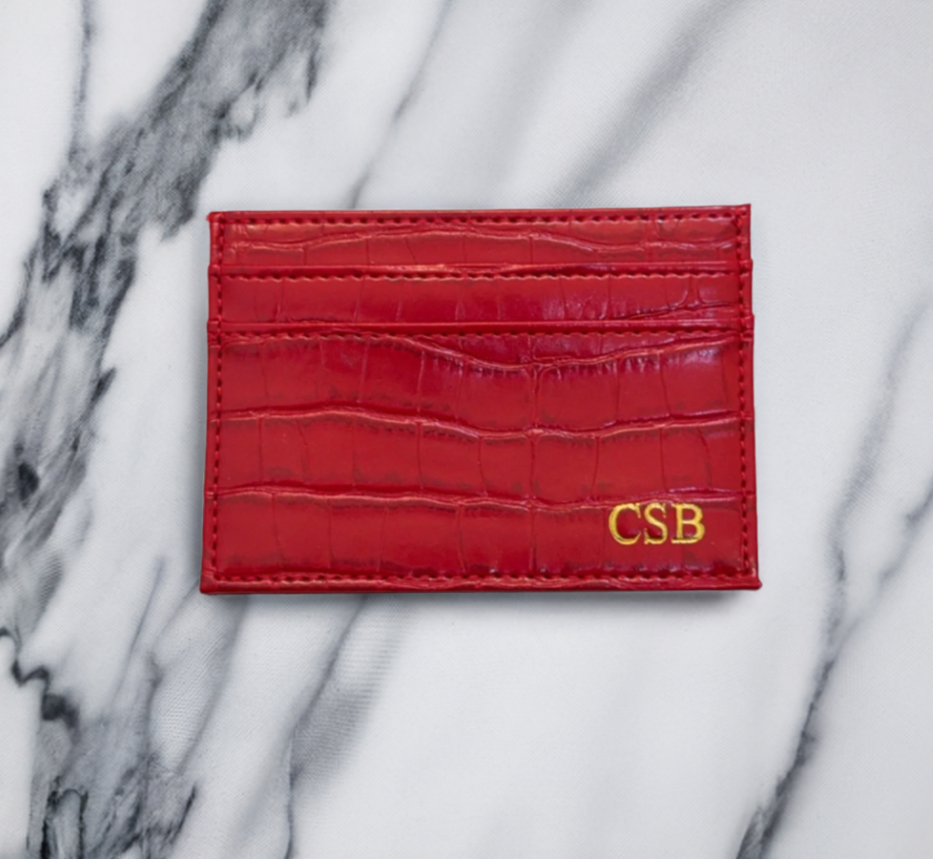 red croc cardholder with gold monogram at bottom right corner